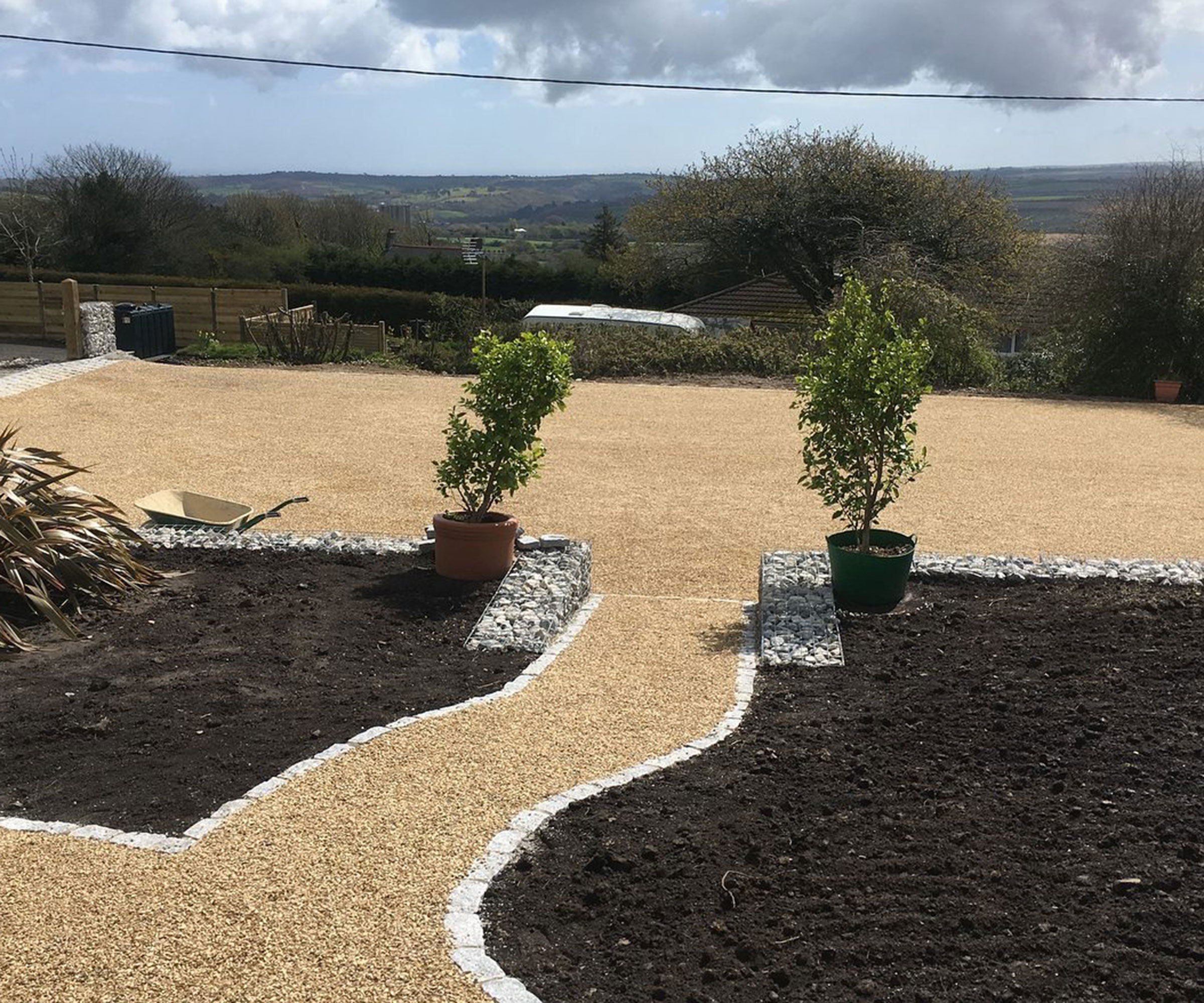 sloping resin driveway with retaining walls