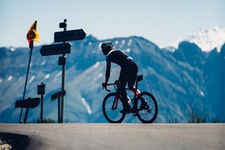 A road cyclist riding with a mountain in the background