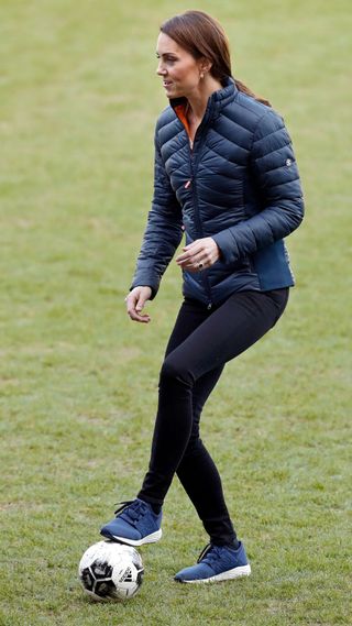 Kate Middleton playing football wearing New Balance trainers