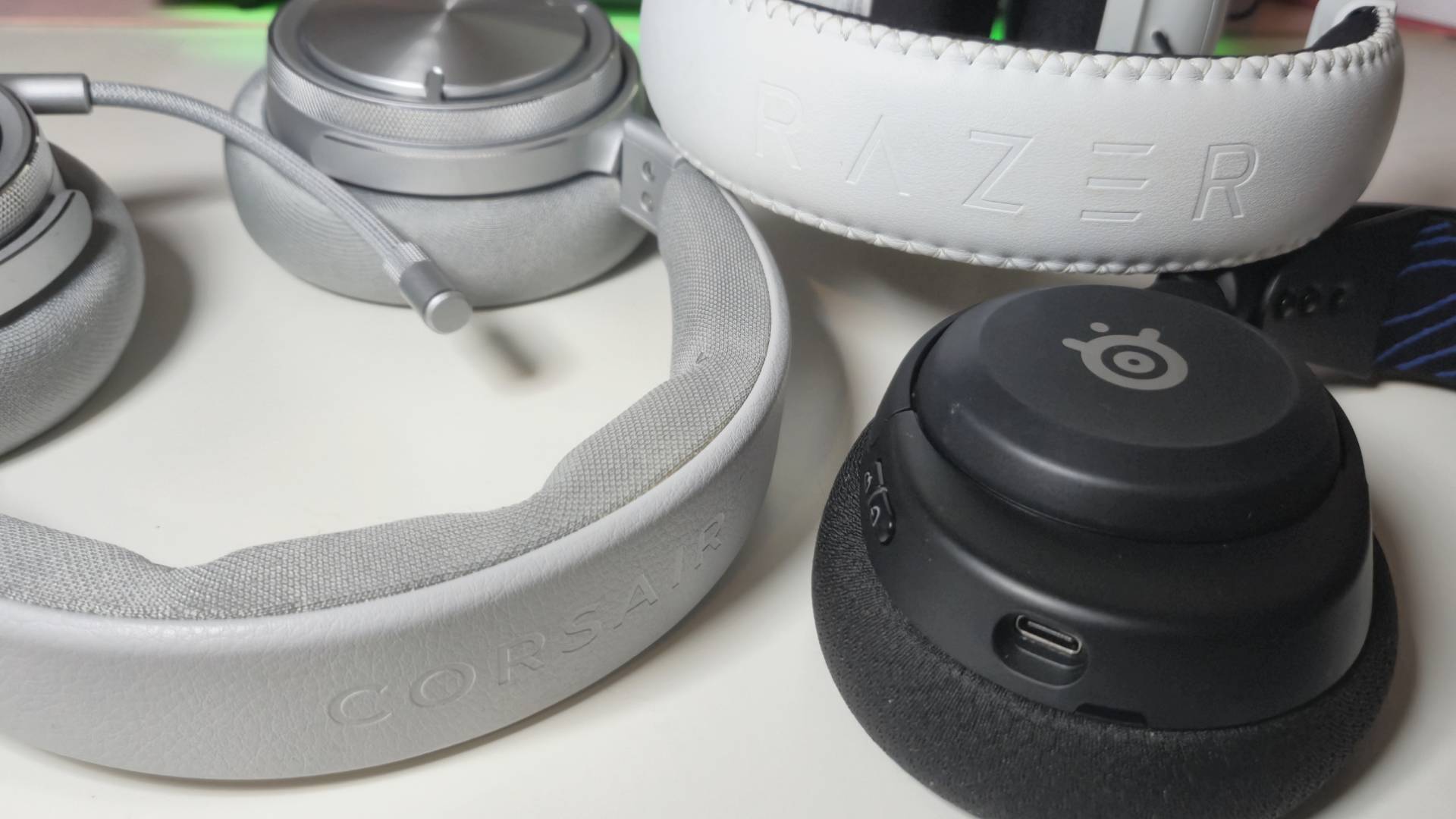 Photo by Rosalie Newcombe of a pile of pc headsets sitting on a white desk.