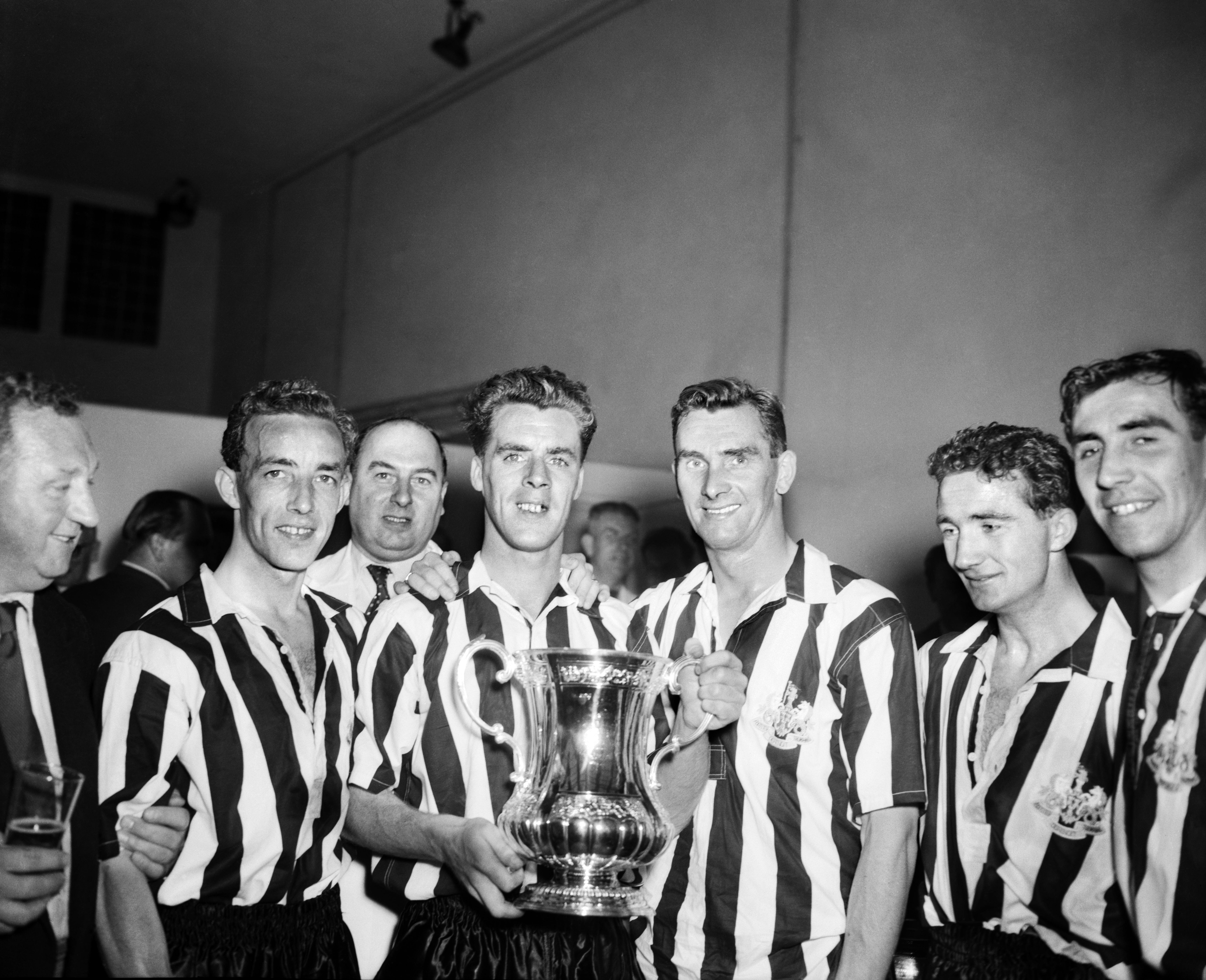 Newcastle players pose with the FA Cup after victory over Manchester City in the 1955 final at Wembley