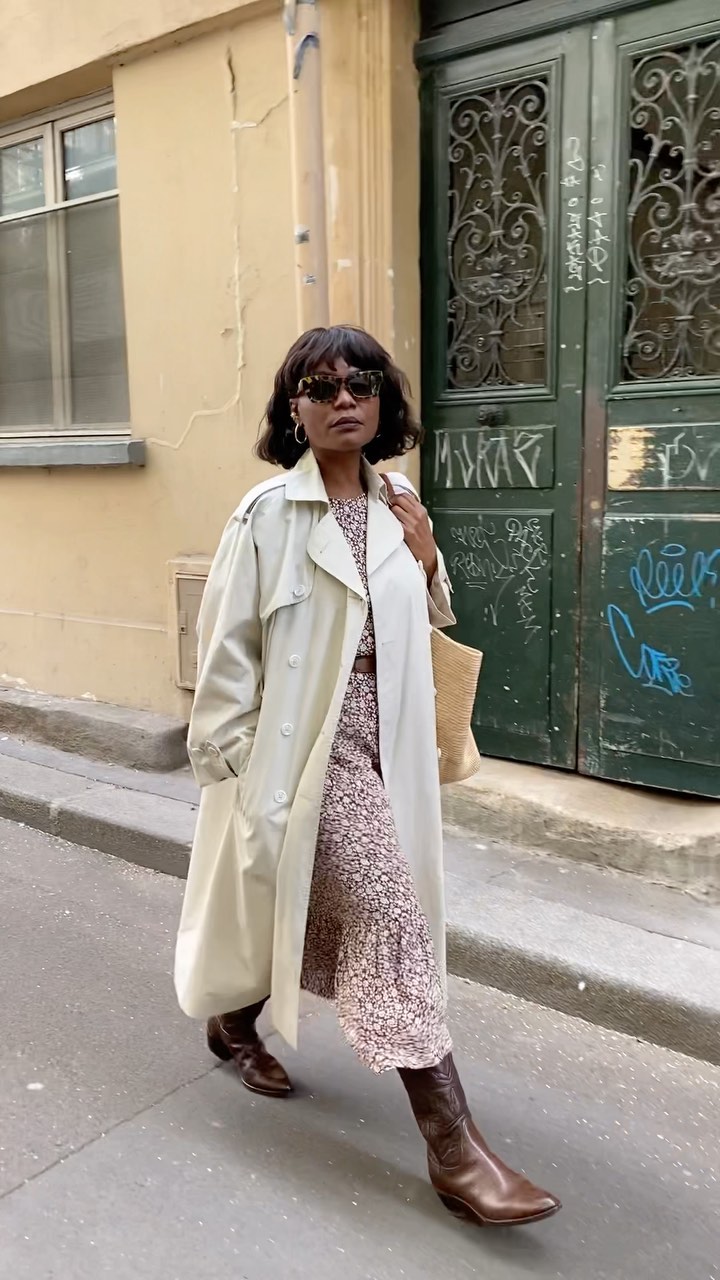 An image of @frannfyne wearing mid-calf boots with a floral midi dress and trench coat.