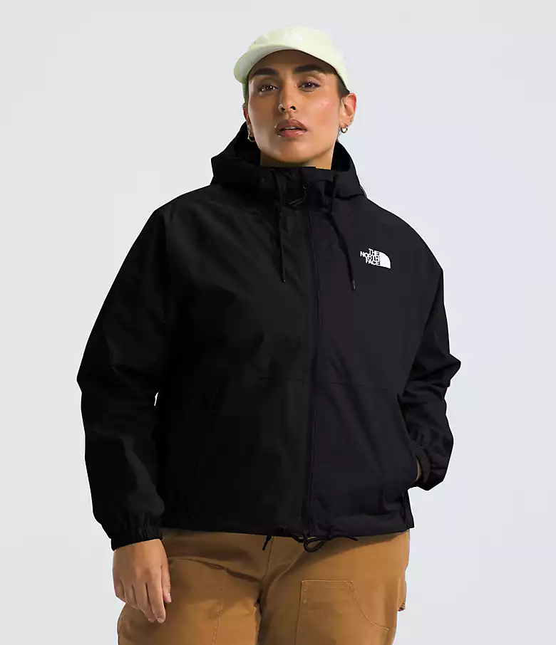model wears black rain jacket and white cap with brown pants 