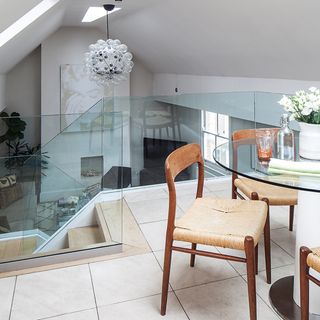 Dining area mezzanine with glass banister overlooking double height living room