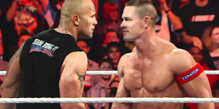 The Rock and John Cena stare each other down in a WWE ring