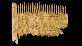 Ornate carvings on the ivory comb depict scenes with animals.