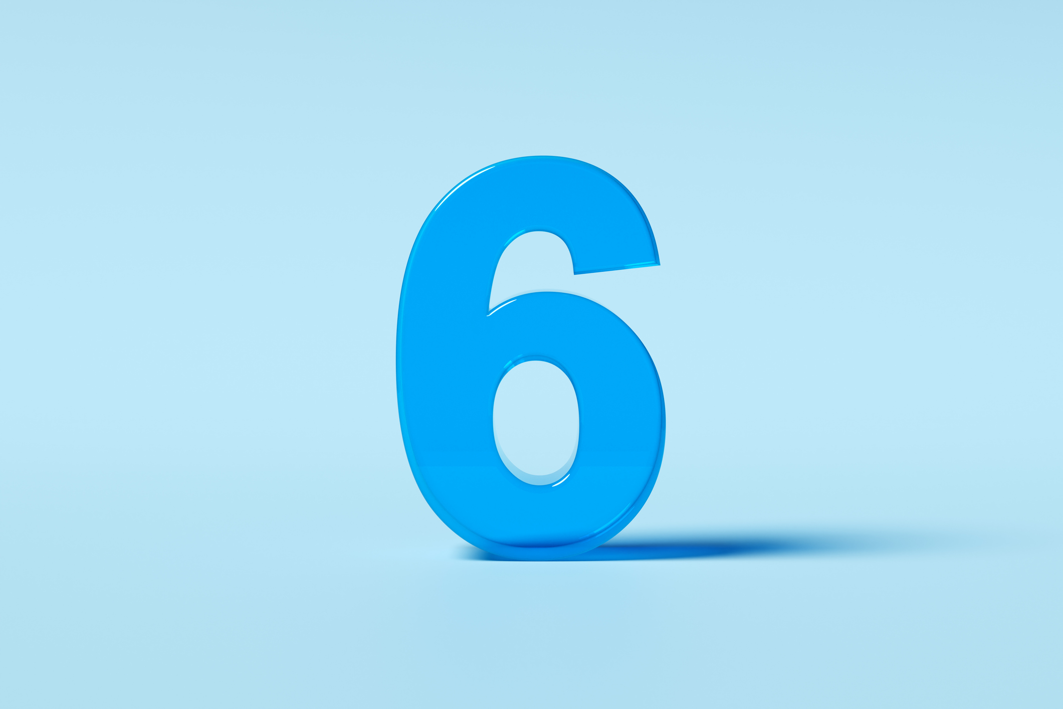 Translucent number six standing on a light blue background