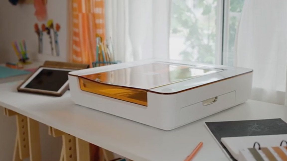 Glowforge Aura; a white laser machine on a desk