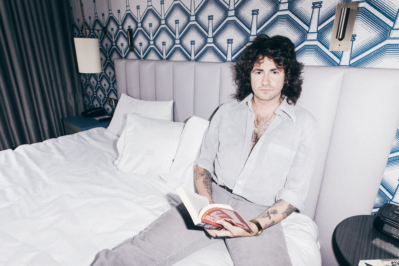 Members of Amyl and the sniffers sat on a bed