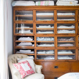 vintage linen press used for storage in a bedroom