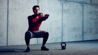 Man performs squat exercise