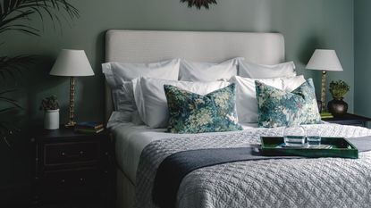 A dark and moody bedroom with vintage blue nightstands