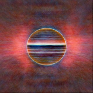 A new radio view of Jupiter at three wavelengths: 2 cm in blue, 3 cm in gold and 6 cm in red. Researchers created this image from 10 hours of data, averaged, so instead of fine detail the features are smeared by the planet's rotation. The pink glow comes from radiation caused by electrons trapped in Jupiter's magnetic field.
