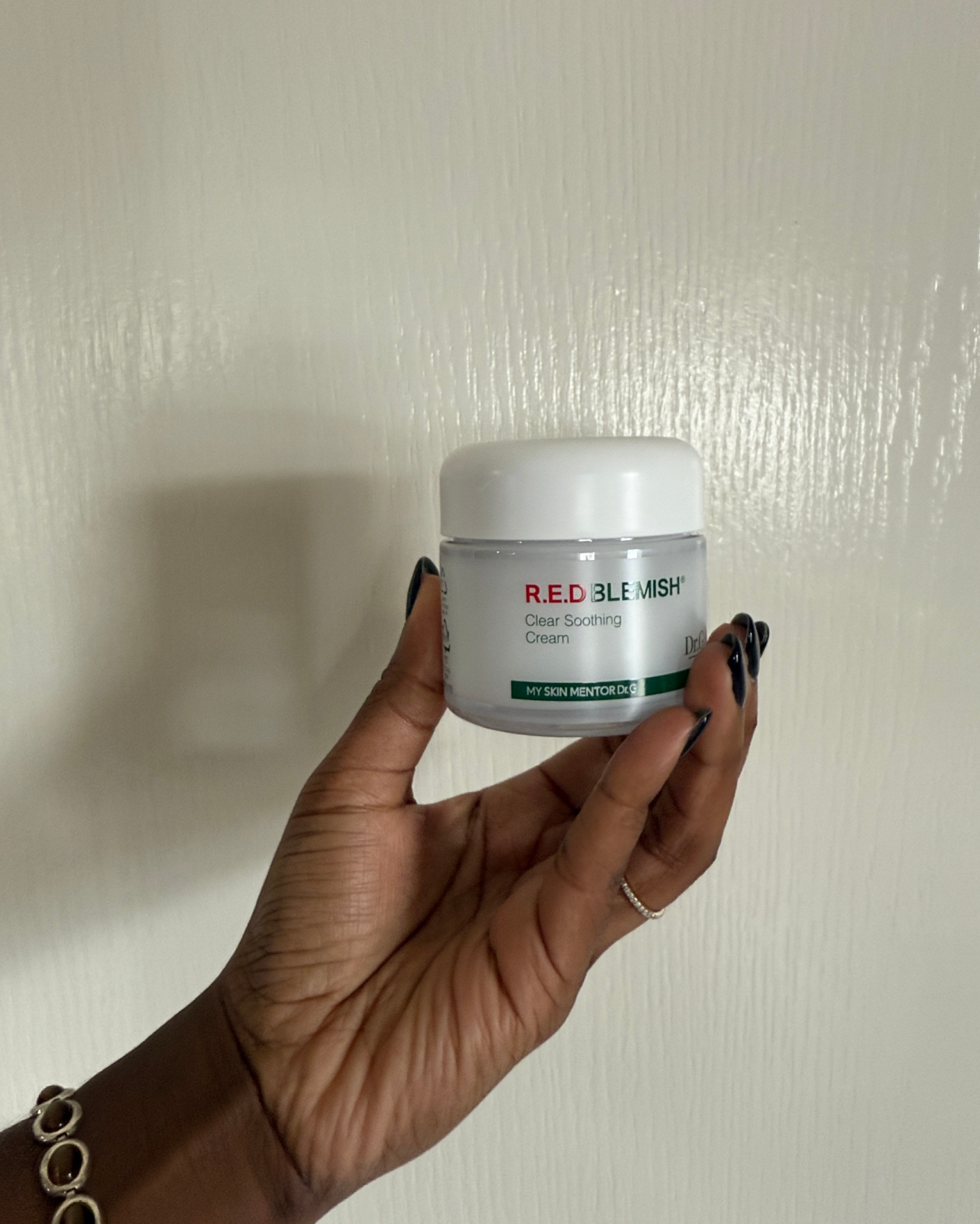 Associate Beauty Editor Maya Thomas displays the Dr. G R.E.D. Blemish Clear Soothing Cream