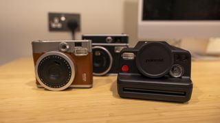 The Polaroid I-2 and two instax cameras on a table