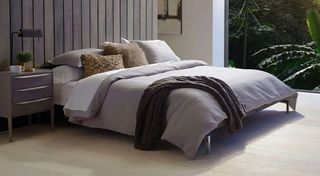 Saatva mattress sale: The Saatva Latex mattress dressed with white and gray linens and pillows
