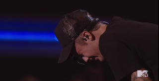Justin Bieber doubled over with his eyes tightly shut as if crying.