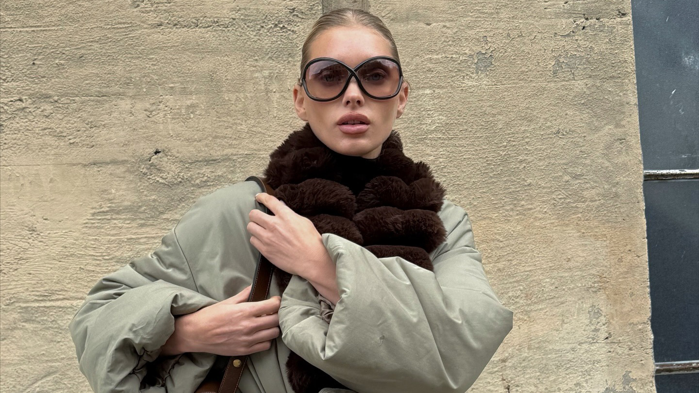 Elsa Hosk wearing a fur-trimmed parka, brown tights, and brown Alaia satin mules