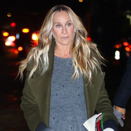 Sarah Jessica Parker walks down the street in New York wearing a polka dot skirt, grey jumper, green jacket and t-bar flats.