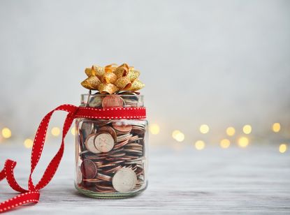 Jar filled with coins and with a Christmas ribbon on top