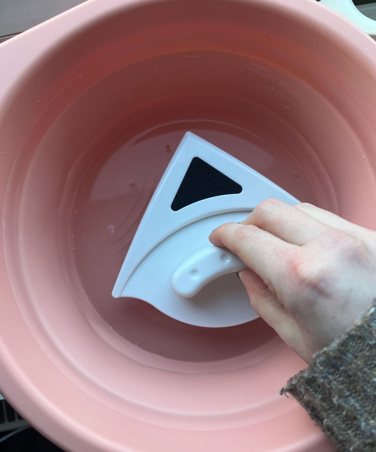 Soaking the cleaning tool in a bucket of water