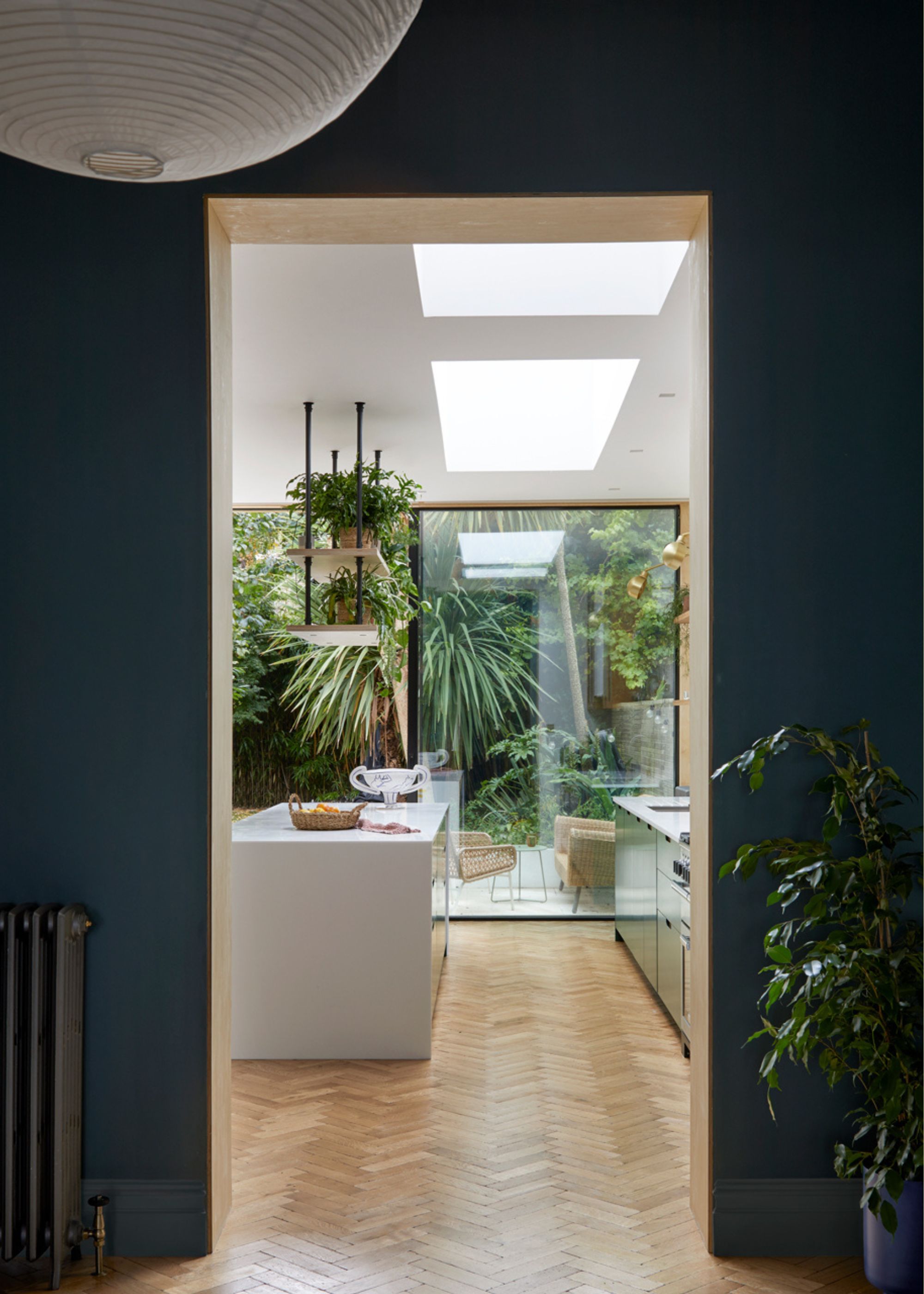 A kitchen with large windows showing off a small outdoor space with plants