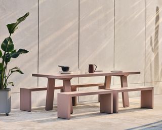 A pink aluminium outdoor dining table and picnic benches