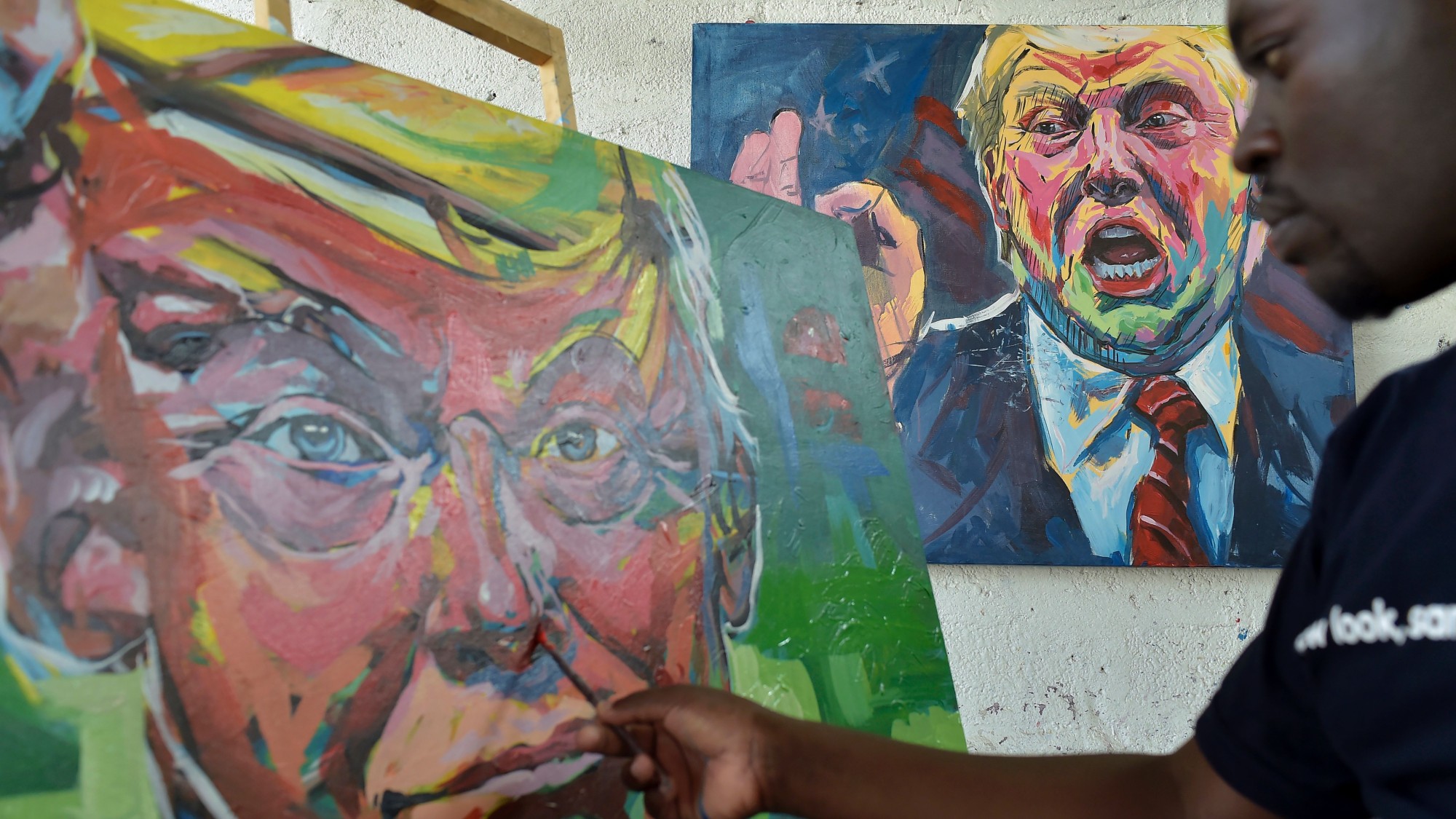 Kenyan artist Evans Yegon aka "Yogonizer" works on his painting of USA President Donald Trump