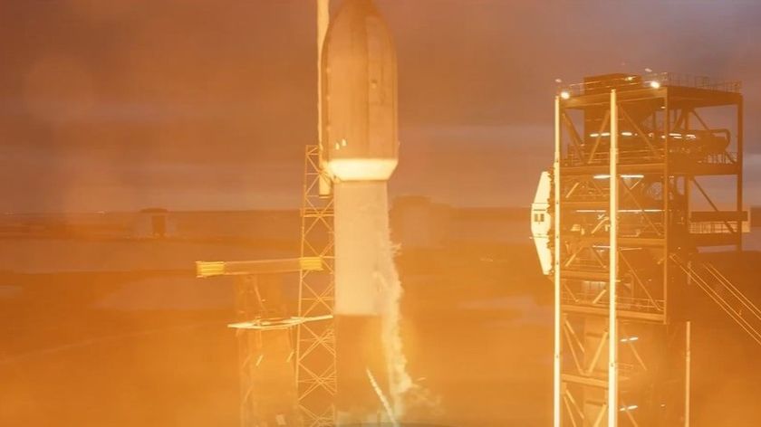 The top of a rocket lifts off amidst a bright orange hue.