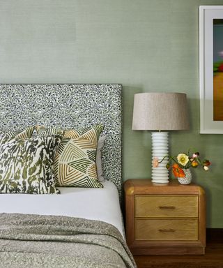 bedroom with green walls and patterned headboard and cushions
