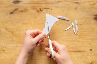 Make paper snowflakes by cutting your design into the folded paper