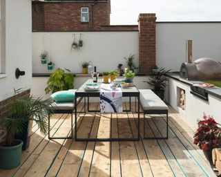 An outdoor dining area with decking, and black table