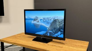 Samsung UE24N4300 TV angle from right on wooden TV stand showing mountains on screen