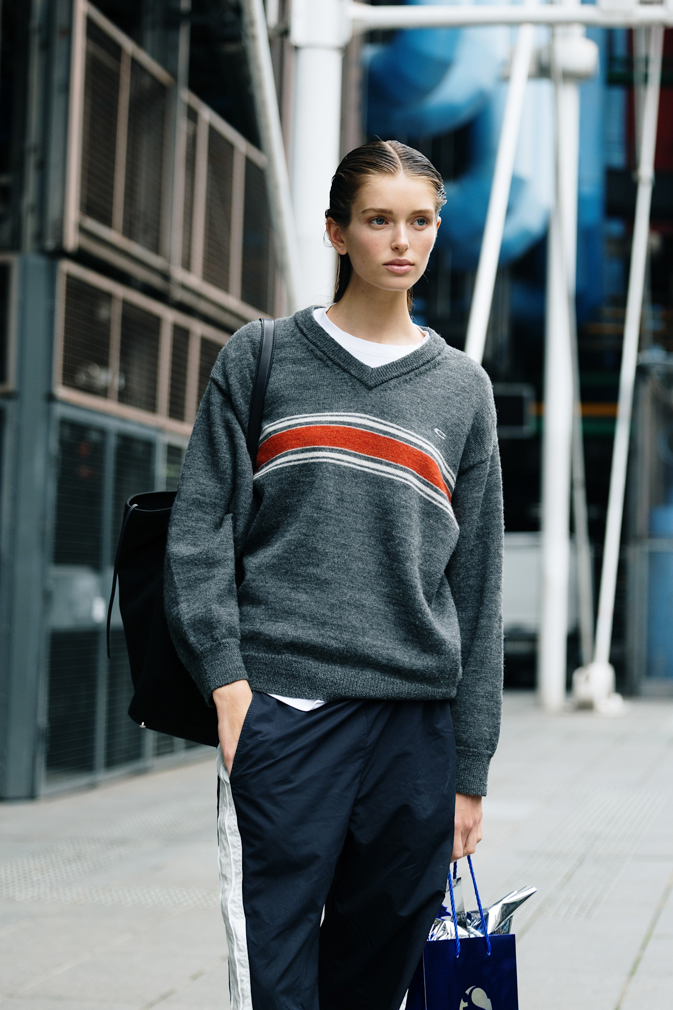Woman in gray sweater and blue track pants.