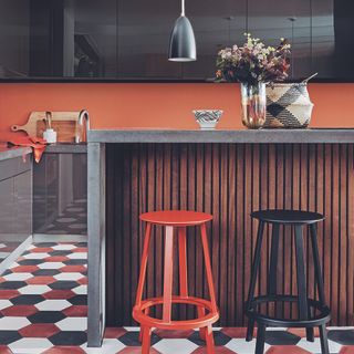 Colourful kitchen with island that has wooden panelling.