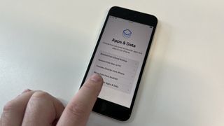 The iPhone set-up menu asking where the user wants to import data from. A finger is pointing at the Move Data from Android option