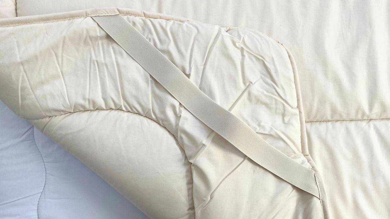 corner of woolroom topper showing elastic fastenings