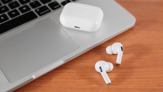 Air Pods Pro. macbook. with Wireless Charging Case. New Airpods pro on wooden background. Airpods.