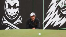 Adrian Meronk crouches down behind a putt at LIV Golf Hong Kong 2024