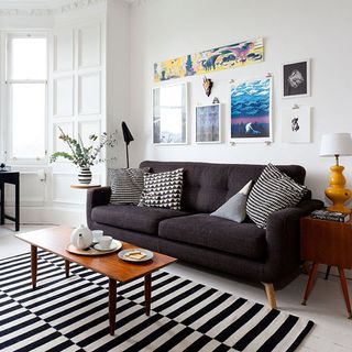 living room with black sofa and wooden coffee table