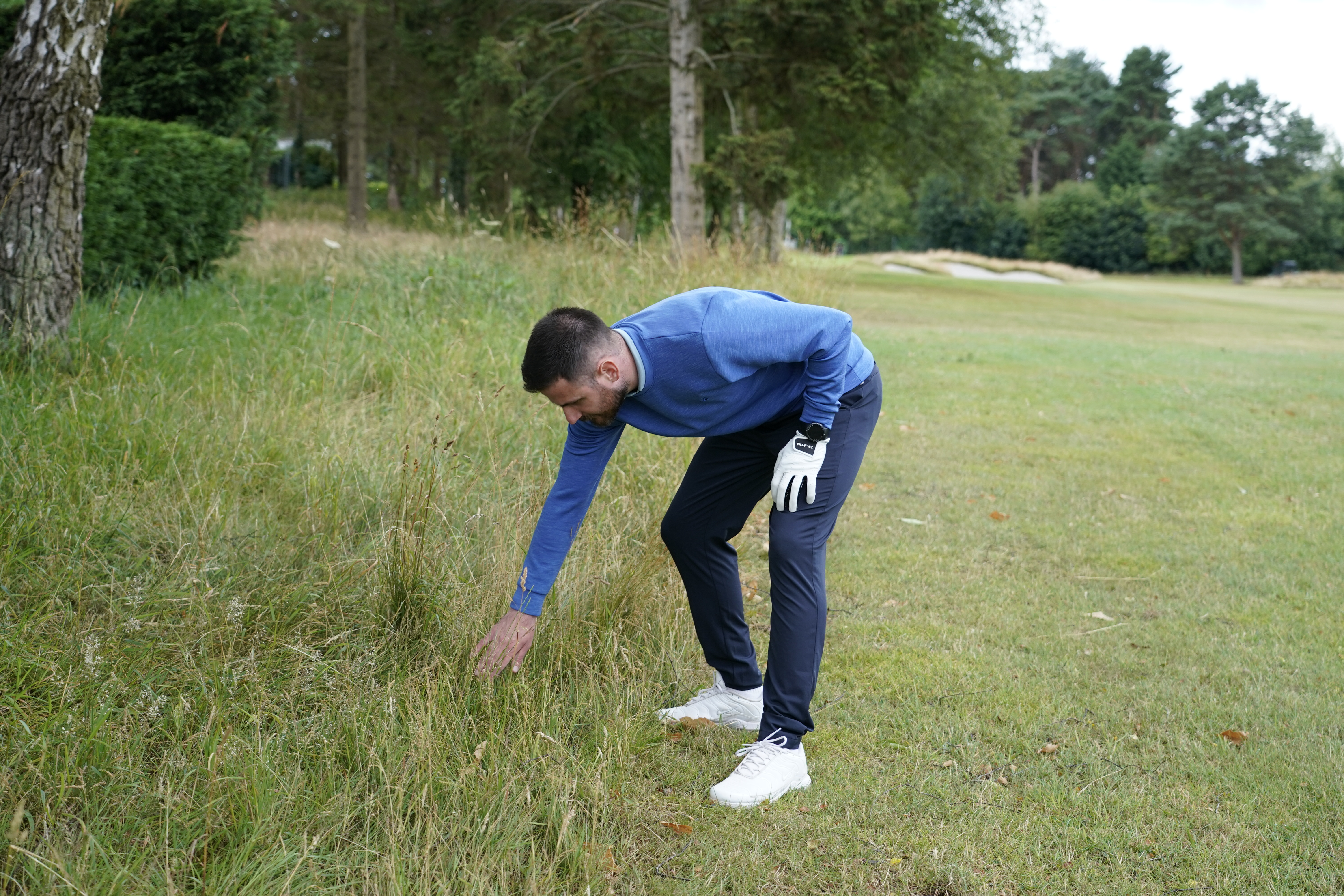 Baz Plummer looking for a lost golf ball in the long rough