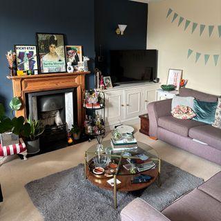 Rebecca's blue living room with fireplace and small grey rug