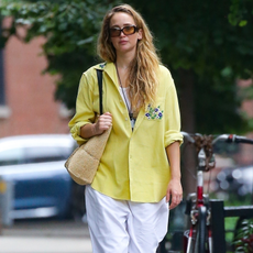Jennifer Lawrence wears yellow shirt, linen pants, sunglasses and fisherman sandals while walking on the street in NYC.