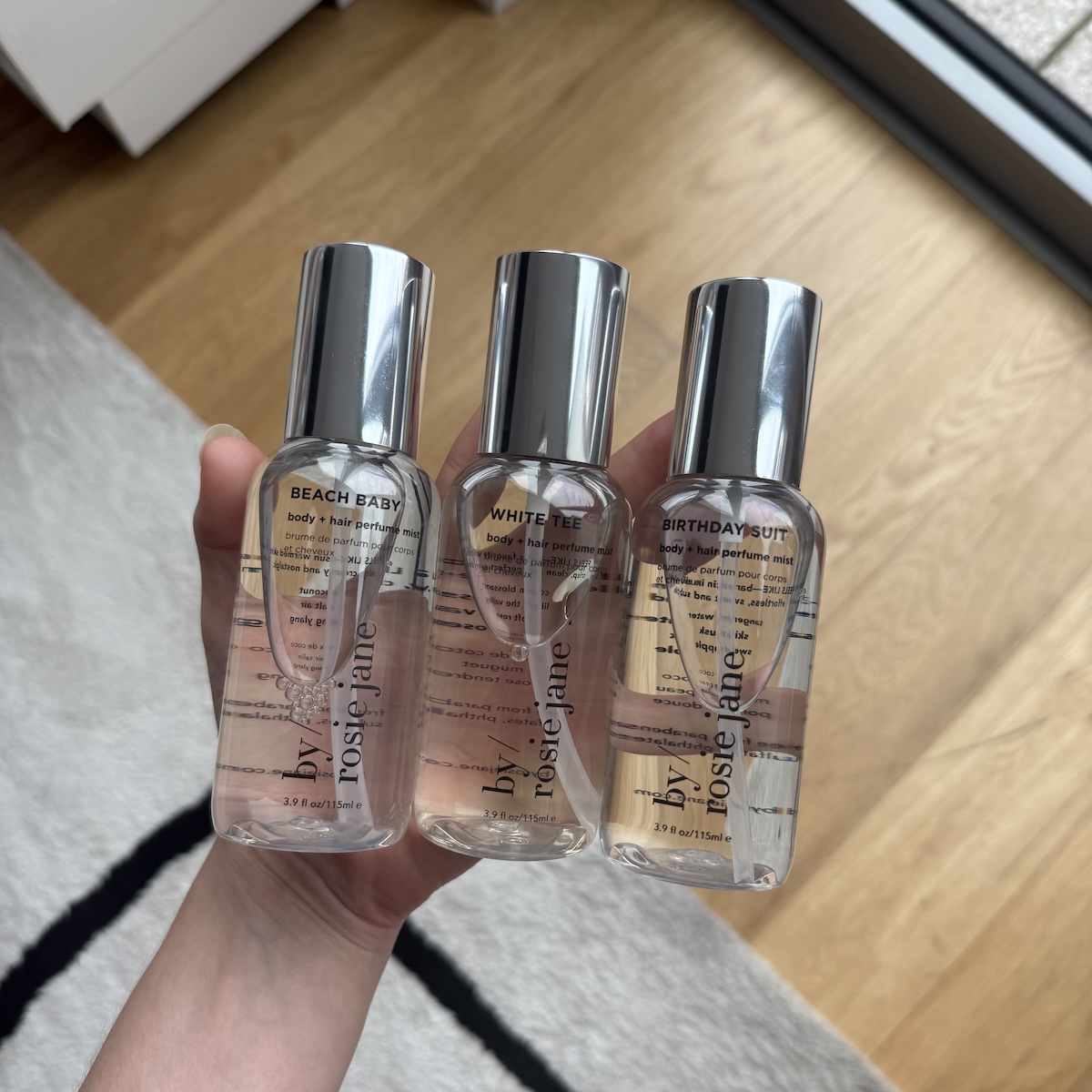 Person holding bottles of By Rosie Jane Body + Hair Mists.