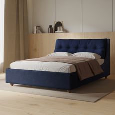 navy upholstered bed with velvet headboard and chenille frame in a light neutral bedroom with light wood flooring and wall panelling