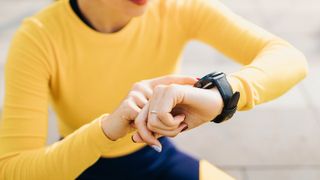 how long should running shoes last: woman checking fitness watch