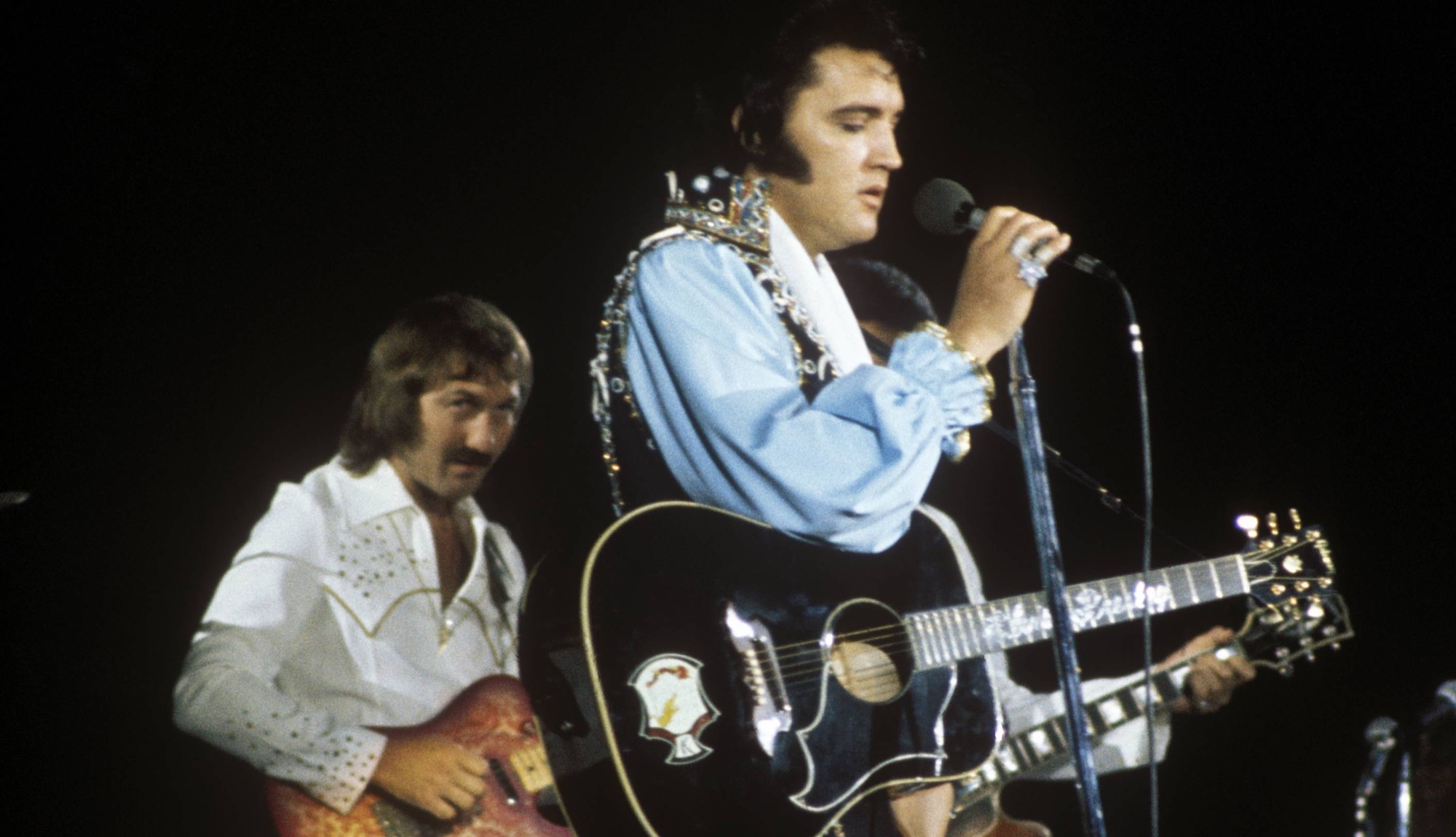 James Burton (left, background) and Elvis Presley onstage in 1974