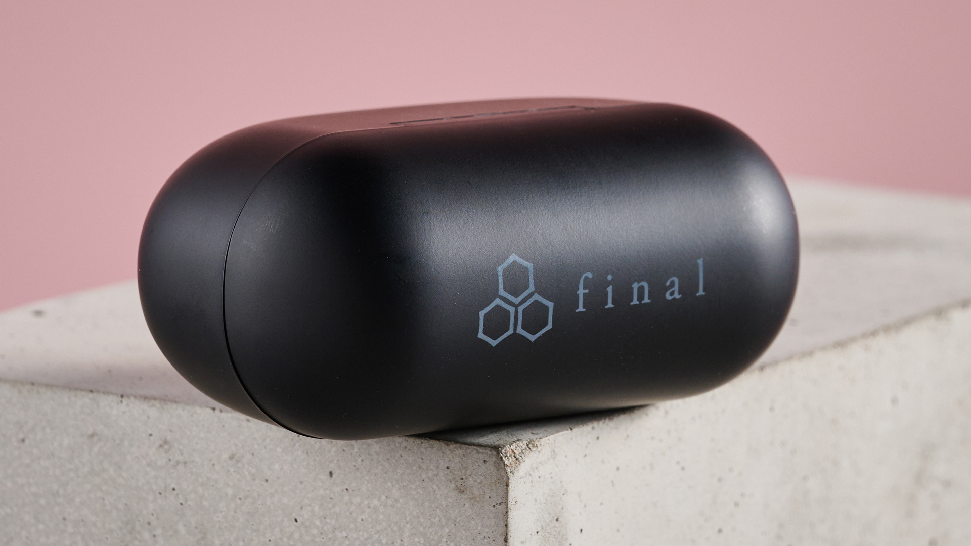Close-up of lid on the case for the Final VR3000 Wireless earbuds, on plinth with pink background