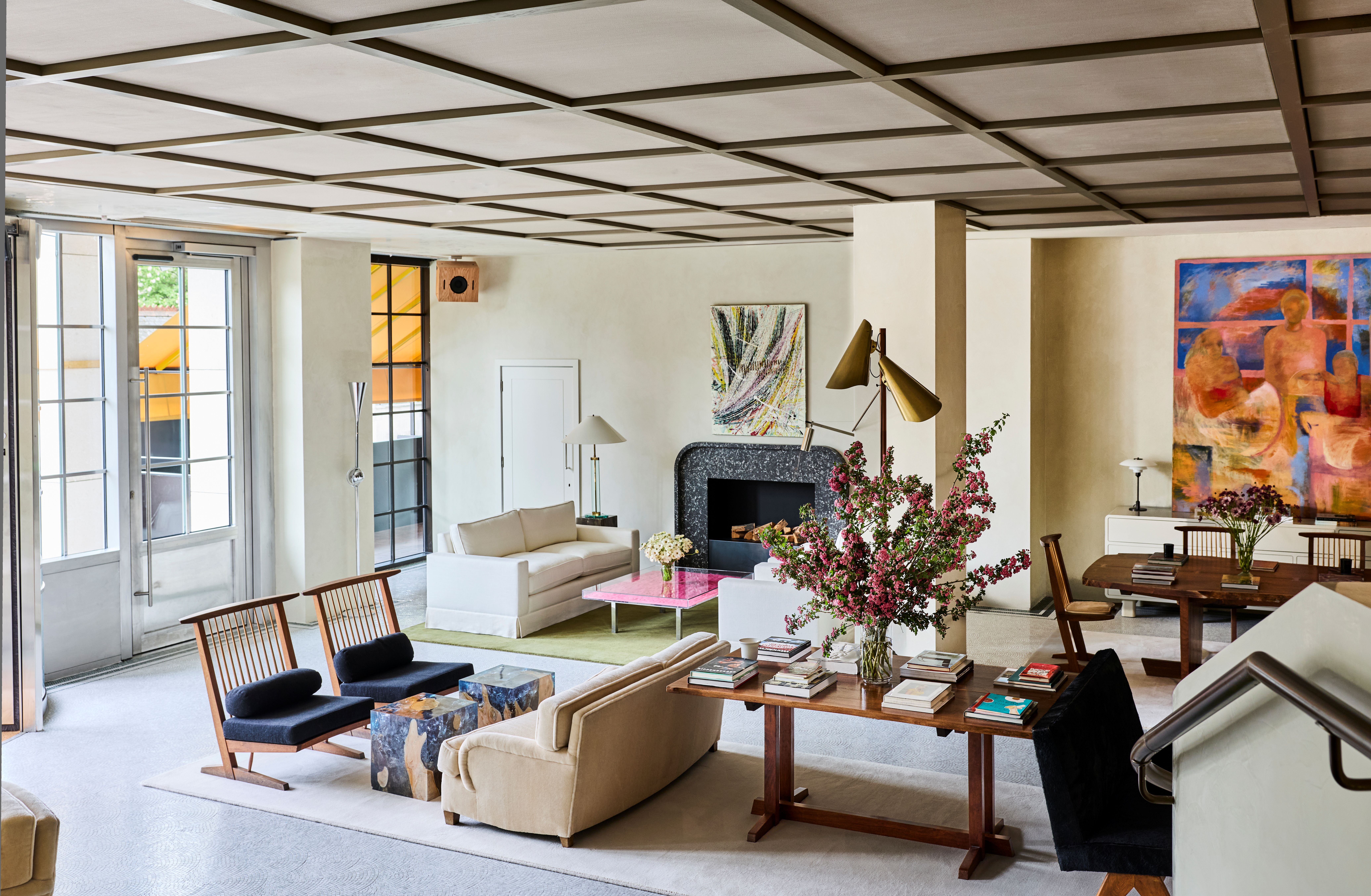 Elegant hotel lobby with green carpeted staircase, floral arrangements and curated contemporary furnishings