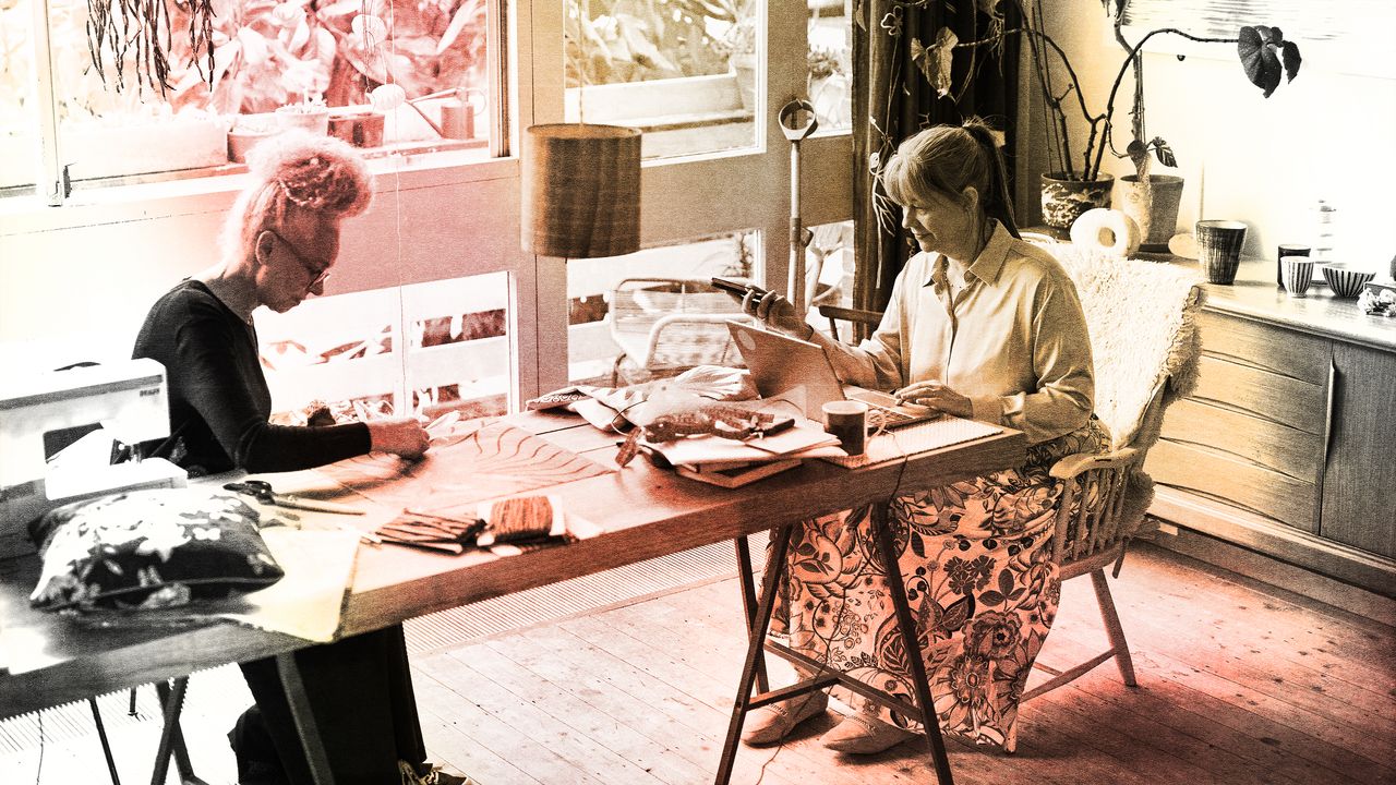 Two middle age woman sitting at a kitchen table together